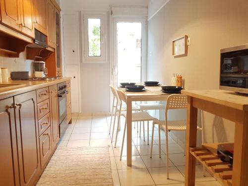 Colourful Apartment in the heart of Athens في أثينا: مطبخ فيه طاوله وبعض الكراسي فيه