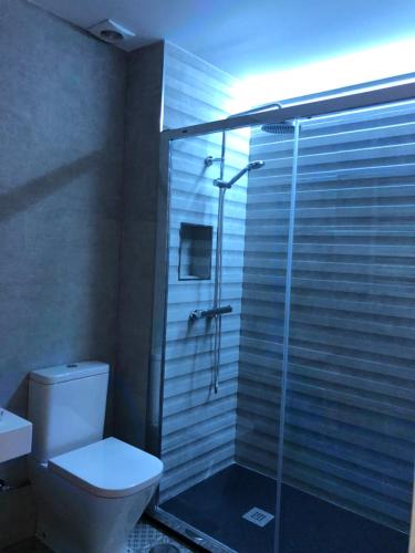 een badkamer met een glazen douche en een toilet bij Apartamento Abuelo Mayorga in Plasencia