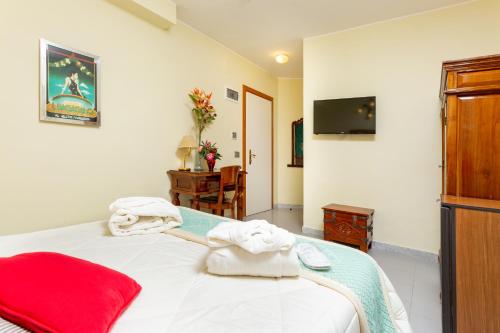 a bedroom with a bed with towels on it at Hotel Marini in Sassari