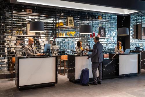 a group of people standing at a counter in a lobby at Ola Santiago Providencia, Tapestry Collection by Hilton in Santiago