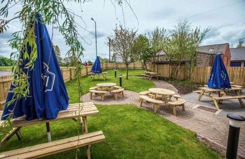 a group of picnic tables and blue umbrellas at Hotel 52 Stanley in Stanley
