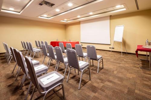 a conference room with a table and chairs and a whiteboard at Best Western Hotel Goldenmile Milan in Trezzano sul Naviglio