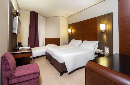トレッツァーノ・スル・ナヴィーリオにあるベスト ウエスタン ホテル ゴールデンマイルの白い大型ベッドと椅子が備わるホテルルームです。