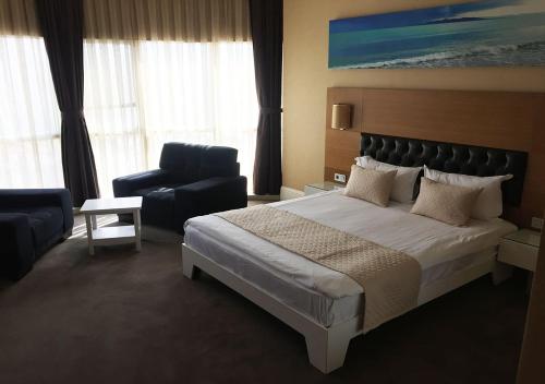 een hotelkamer met een bed en een stoel bij City Hotel Plovdiv in Plovdiv