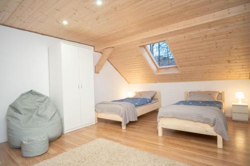 two beds in a room with wooden ceilings at Apartamenty GoszoWita in Stronie Śląskie