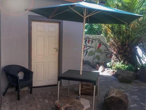 a table with a blue umbrella next to a door at Cheryl's Fortress in Johannesburg