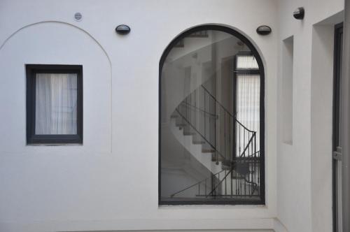 an arched window in a white building with a staircase at Centrál Vendégház Székesfehérvár in Székesfehérvár