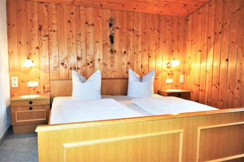 a bedroom with a large bed with wooden walls at Haus Grassa in Brand