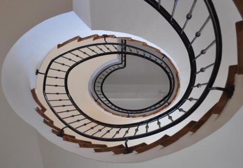 a spiral staircase in a building with a mirror at Centrál Vendégház Székesfehérvár in Székesfehérvár