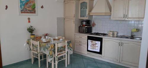 
a kitchen with a table and a microwave at Villa Antica Macina in Positano
