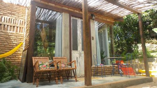a screened in porch with two chairs and a table at Zazen Pousada by Santoregano in Maceió