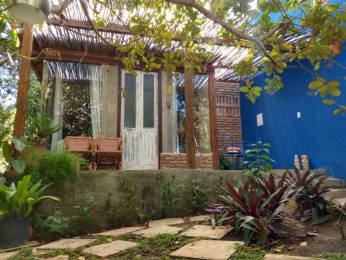 a house with a blue wall and a pergola at Zazen Pousada by Santoregano in Maceió