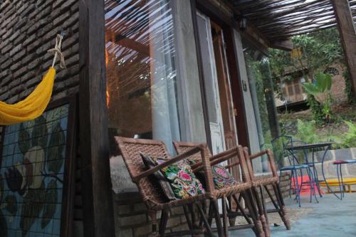 a group of chairs sitting outside of a building at Zazen Pousada by Santoregano in Maceió