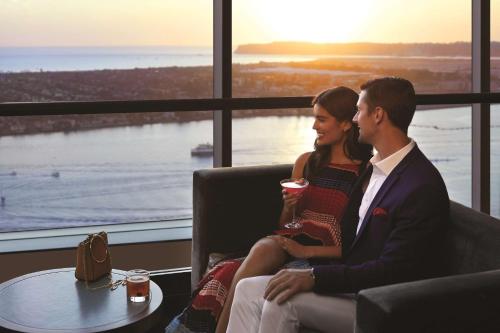 a man and woman sitting on a couch watching the sunset at Manchester Grand Hyatt San Diego in San Diego