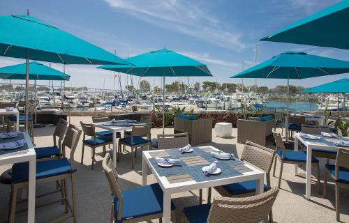 a restaurant with tables and chairs with blue umbrellas at Manchester Grand Hyatt San Diego in San Diego