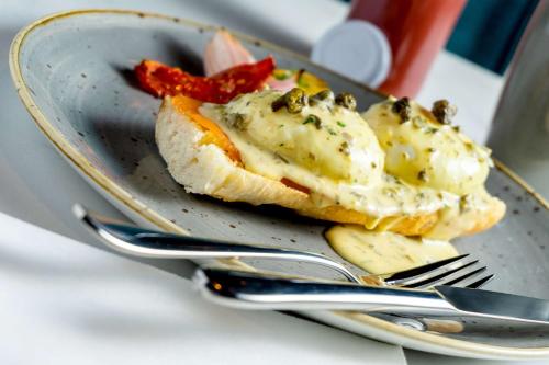 a plate with a piece of bread with cheese and fruit at Hyatt Centric Las Condes Santiago in Santiago
