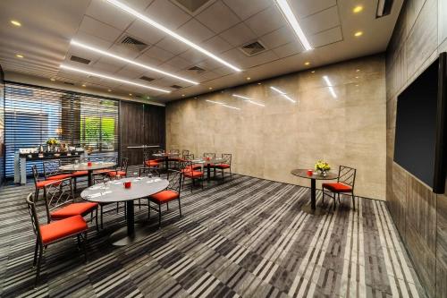 a restaurant with tables and chairs and a flat screen tv at Hyatt Centric Las Condes Santiago in Santiago