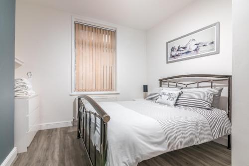 a white bedroom with a bed and a window at PLATFORM Avenues Apartment 1 in Hull
