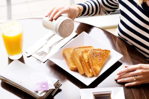 a table with a plate of toast and a drink at Hyatt Place Dallas/Grapevine in Grapevine