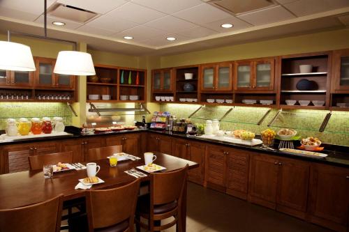 a kitchen with wooden cabinets and a table and chairs at Hyatt Place Orlando Airport in Orlando