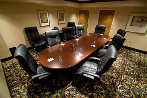 a conference room with a wooden table and black chairs at Staybridge Suites Williamsville Buffalo by IHG in Williamsville