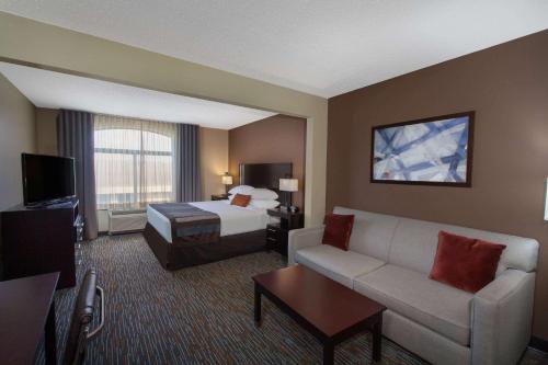 a hotel room with a bed and a couch at Wingate by Wyndham Oklahoma City Airport in Oklahoma City