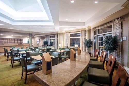 a restaurant with tables and chairs in a room at La Quinta by Wyndham Charlotte Airport South in Charlotte