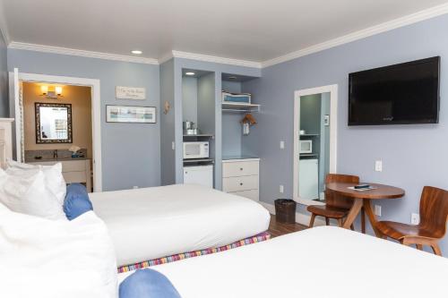 a hotel room with a bed and a television at Beach Street Inn and Suites in Santa Cruz