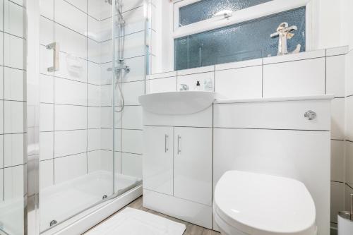 a white bathroom with a toilet and a sink at PLATFORM Avenues Apartment 1 in Hull