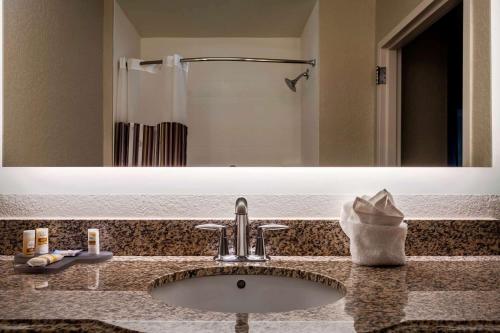 a bathroom with a sink and a large mirror at La Quinta by Wyndham Port Orange / Daytona in Port Orange