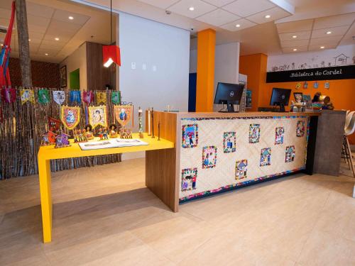 a store with a yellow table and a counter at ibis Styles Campina Grande in Campina Grande