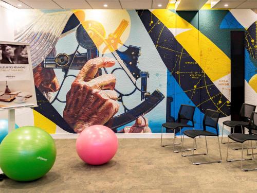 a room with a wall with a painting of a hand at Mercure Le Havre Centre Bassin Du Commerce in Le Havre
