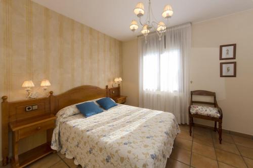 a bedroom with a bed and a window and a chair at Casa Puyuelo Tierrantona in Tierrantona