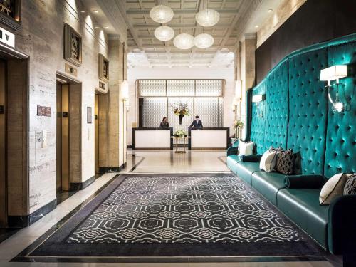 a lobby with a blue wall with couches and a table at Sofitel Lafayette Square Washington DC in Washington