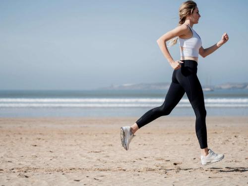 a woman running on the beach at Le Médina Essaouira Thalassa Sea & Spa - MGallery Collection in Essaouira
