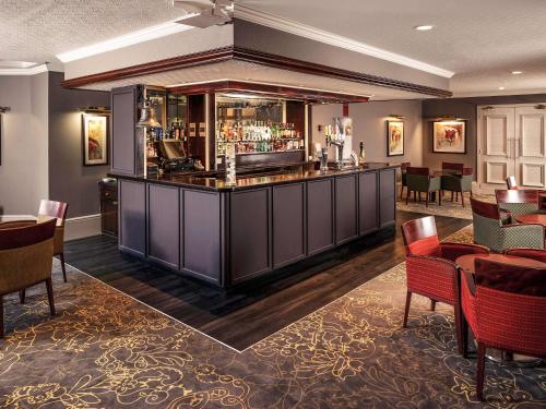 a bar in a hotel room with tables and chairs at Mercure Bradford, Bankfield Hotel in Bradford