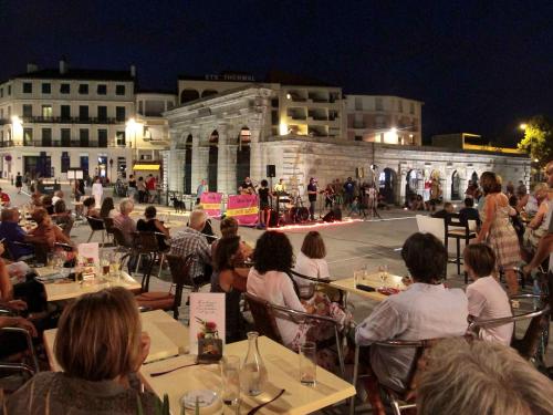 a group of people sitting at tables watching a performance at ibis budget Saint Paul Les Dax in Saint-Paul-lès-Dax