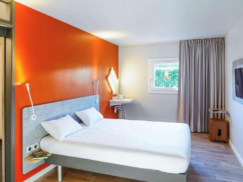 Ένα ή περισσότερα κρεβάτια σε δωμάτιο στο Ibis Budget Aubenas
