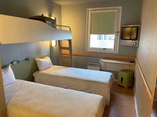 a hotel room with two beds and a window at Ibis budget Verdun in Verdun