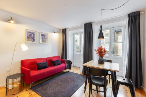 a living room with a red couch and a table at Porto Center Apartments in Porto