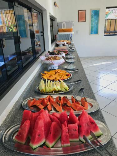 a row of plates of fruit on a buffet at Pousada do Boto in Garopaba