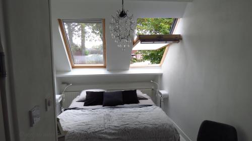 een kleine slaapkamer met een bed en een raam bij B&B Bij Bijnen in Soerendonk