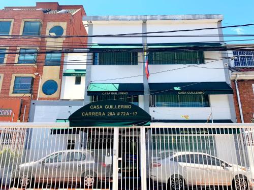 two white cars parked in front of a building at Hotel Casa Guillermo in Bogotá