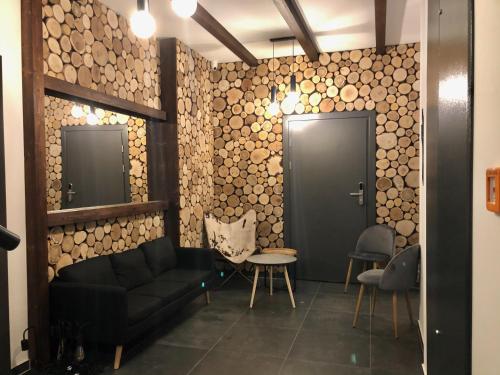 a living room with a black couch and two mirrors at Aparthotel Narciarska 2 in Korbielów