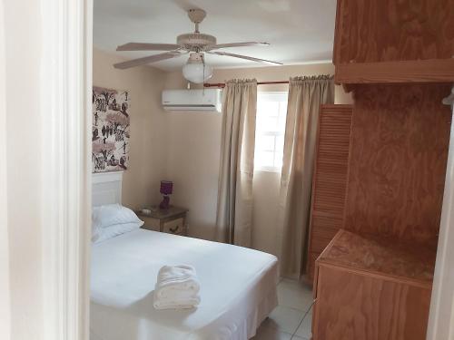 a bedroom with a bed and a ceiling fan at Clearwater Apartments in Christ Church