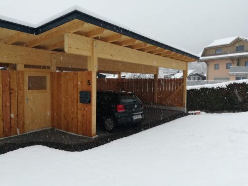 a car parked under a wooden garage in the snow at Das K - dei "Hoamatl" im Ötztal in Oetz