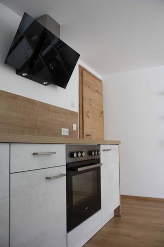 a kitchen with a stove and a microwave at Das K - dei "Hoamatl" im Ötztal in Oetz