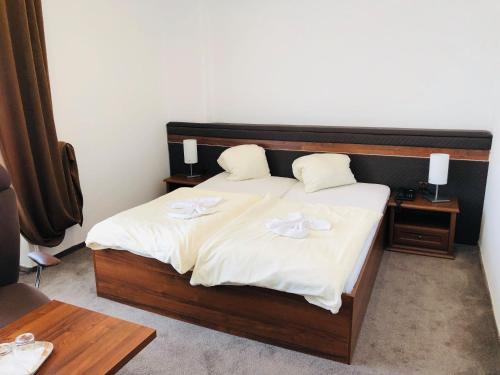 una camera da letto con letto, lenzuola e cuscini bianchi di Hotel Piast a Český Těšín