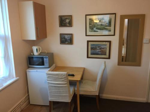 a small kitchen with a table and a microwave at Central Greenwich guest rooms in London