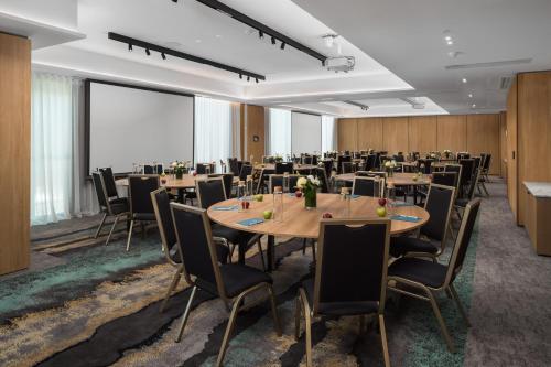 a conference room with tables and chairs in a room at Crystalbrook Bailey in Cairns